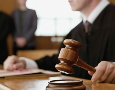 Judge holding gavel in courtroom
