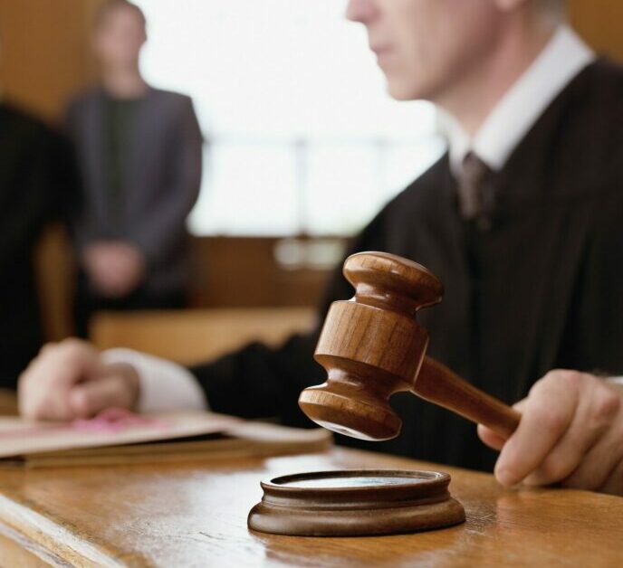 Judge holding gavel in courtroom
