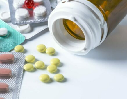 White medical pills for a phial on a white background