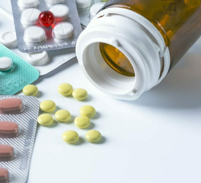 White medical pills for a phial on a white background