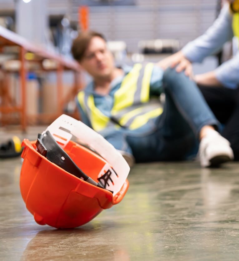 Men worker feel painful and hurt from the accident that happen inside of industrial factory while his co-worker come to give emergency assistance and help.