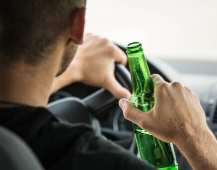 Man drinking beer while driving