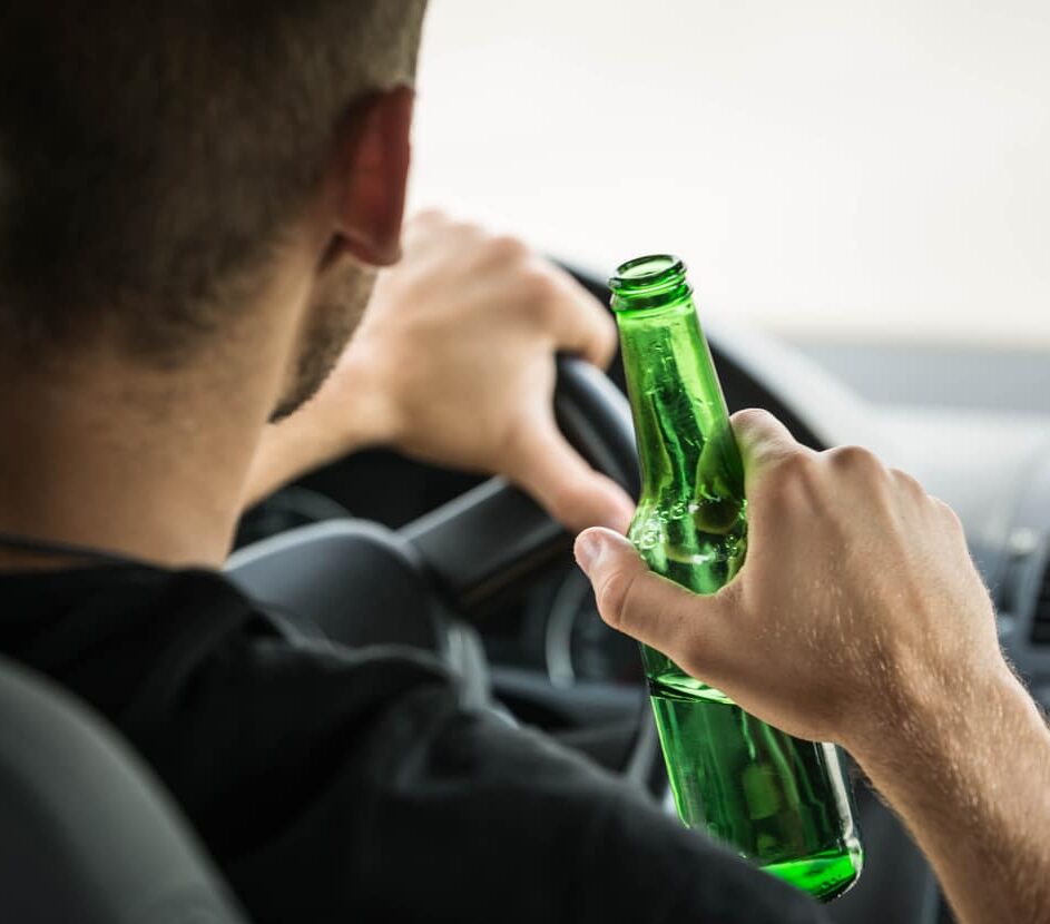 Man drinking beer while driving